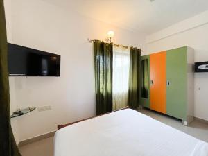 1 dormitorio con 1 cama y TV de pantalla plana en Rainforest - Casa Del Sol, Anjuna - 3 kms from the beach, en Anjuna