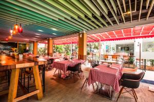 a restaurant with tables and chairs in a room at Kudos Parc Pattaya in Pattaya South