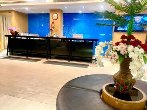 a lobby with a grand piano and a vase of flowers at Kudos Parc Pattaya in Pattaya South