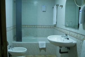 a bathroom with a sink and a bath tub at Hotel Pizarro in Humanes de Madrid