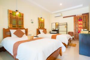 清萊的住宿－吉塔之家旅館，一间卧室配有两张带白色床单的床