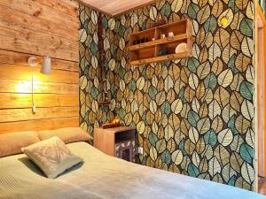 a bedroom with a bed and a wall with a mosaic at Ennu’s hut in Loksa