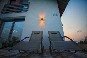 two chairs sitting on a patio in front of a building at Na Skraju Raju in Zator