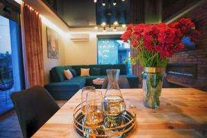 a table with a vase of flowers and two glasses at Na Skraju Raju in Zator
