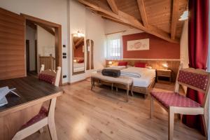 a bedroom with a bed and a table and chairs at Les Gomines BB***** in San Vigilio Di Marebbe