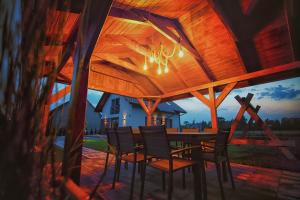 a dining table and chairs under a wooden ceiling at Na Skraju Raju in Zator