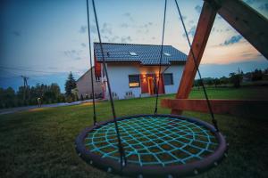 a swing in a yard in front of a house at Na Skraju Raju in Zator