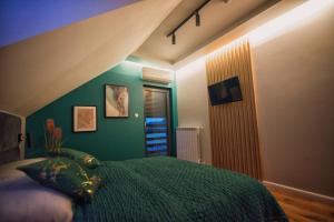 a bedroom with a bed and a green wall at Na Skraju Raju in Zator