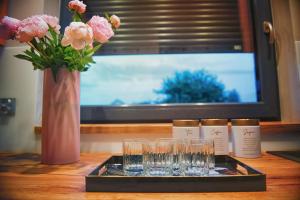 a tray with glasses and a vase with flowers on a table at Na Skraju Raju in Zator