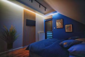 a bedroom with blue walls and a bed with blue pillows at Na Skraju Raju in Zator