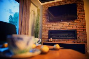 a living room with a brick fireplace with a television at Na Skraju Raju in Zator