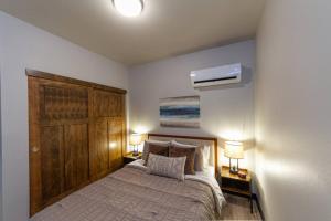 1 dormitorio con 1 cama con 2 mesitas de noche y 2 lámparas en Wonderful Triplex Unit With Spectacular Lake View! en Valley