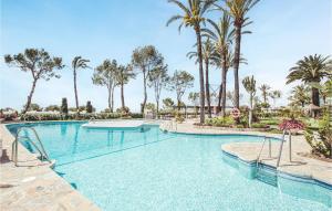 - une piscine avec des palmiers dans un complexe dans l'établissement Beautiful Apartment In Mlaga With House A Panoramic View, à Malaga