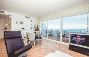 - un salon avec une télévision, une table et des chaises dans l'établissement Beautiful Apartment In Mlaga With House A Panoramic View, à Malaga