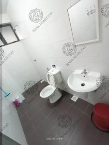 a bathroom with a white toilet and a sink at Nana Homestay Malay Only in Kampong Chepor