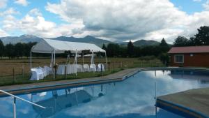 a person standing next to a swimming pool with a tent at Villa Baviera, Hotel Baviera Chile in La Máquina