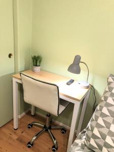 een bureau met een lamp en een stoel naast een bed bij Harvest moon room with TV near Wine Country in Hemet