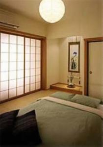 a bedroom with a bed and a large window at Shizuka Ryokan Japanese Country Spa & Wellness Retreat in Hepburn Springs