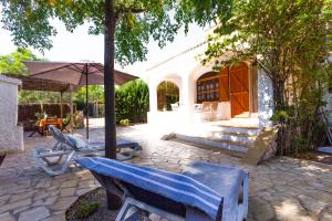 Un patio con una mesa y sillas y una sombrilla. en INNOUTHOME A 100m de la playa Port de l'Estany II, en L'Ametlla de Mar 34 fotos más