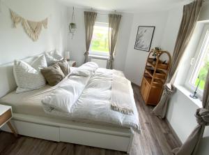 a bedroom with a bed with white sheets and pillows at Schöne Wohnung mit Terrasse & Blick ins Grüne in Dormettingen
