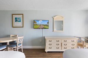 a dining room with a table and a dresser at SeaMist Driftwood Vacation Studio with Balcony in Myrtle Beach