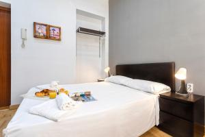 - un lit blanc avec un plateau de nourriture dans l'établissement Livemalaga Letrán Apartment, à Malaga