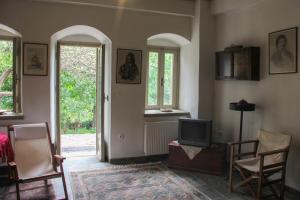 salon z telewizorem i dwoma oknami w obiekcie The Stonehouse w mieście Stemnitsa