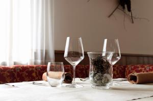 a table with two wine glasses and a vase on it at Hotel Belfiore in Monclassico