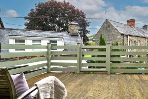 a white fence on a deck with a house at Finest Retreats - Hope House - Ty Gobaith in Dolgellau