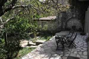 een patio met een tafel en stoelen in een tuin bij The Stonehouse in Stemnitsa