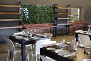 a dining room with black tables and white chairs at Waterberg Game Lodge in Bela-Bela