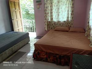 una camera con due letti e una porta con balcone di Iman D'Semungkis Resort & Training Center Hulu Langat a Hulu Langat