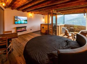 a bedroom with a large bed and a tv on the wall at Chalet Cormignano in Vezza dʼOglio