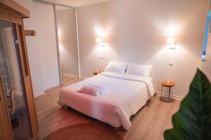 um quarto com uma cama grande e uma colcha branca em Slocations em Vandoeuvre-lès-Nancy