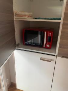 un forno a microonde rosso seduto sopra un mobile bianco di New Luxury Apartment, Milan City Center a Milano