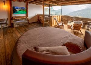a bedroom with a large bed in a room with a tv at Chalet Cormignano in Vezza dʼOglio