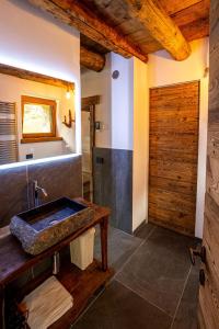 a bathroom with a sink and a wooden door at Chalet Cormignano in Vezza dʼOglio