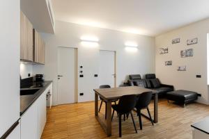 米蘭的住宿－Easylife - Moderno bilocale in zona Porta Romana，厨房以及带桌椅的起居室。