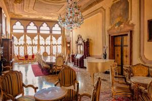威尼斯的住宿－Palazzo Ca' Bernardo By Francesco Molon，配有桌椅和吊灯的客房