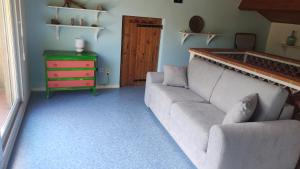 uma sala de estar com um sofá e uma cómoda em La clairière em Pierrelongue
