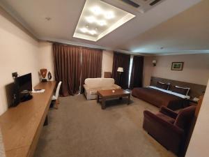 um quarto de hotel com uma cama e uma sala de estar em Sheki Olimp Villa em Sheki