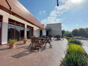 a patio with chairs and tables outside of a building at Arena Hotel Sheki in Sheki