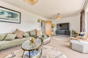 a living room with a couch and a table at Cliff Top Heights-Beach front house near Brighton in Rottingdean
