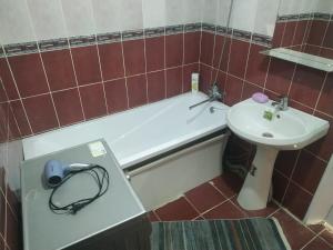 a bathroom with a sink and a tub and a toilet at Avtovokzal 3 Room apt in Qyzylorda
