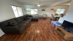 una sala de estar con un sofá y un televisor en Frangipani Cottage, en Jurien Bay