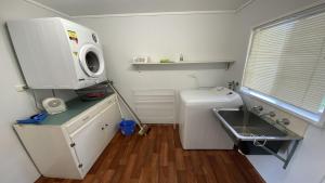 Una pequeña cocina con fregadero y microondas. en Frangipani Cottage, en Jurien Bay 5 fotos más