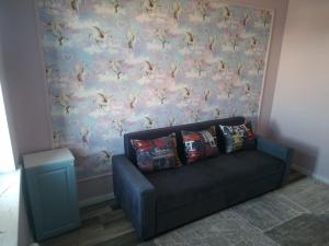 a couch in a living room with a wall at Avtovokzal 3 Room apt in Qyzylorda