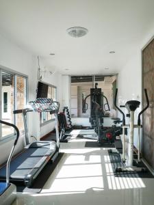 een fitnessruimte met loopbanden en machines in een kamer bij Fang Villa Hotel in Fang