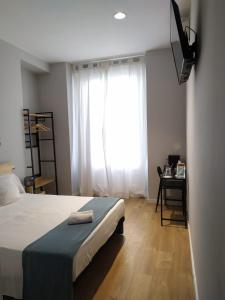 1 dormitorio con cama y ventana grande en Marina Rooms, en Madrid