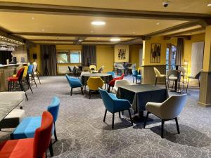 a restaurant with tables and chairs in a room at Le Vancouver in La Plagne